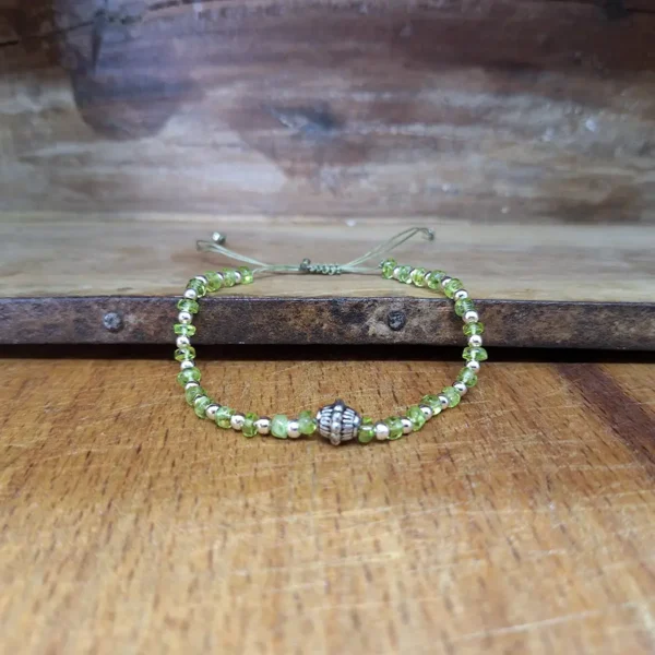 Perlenarmband aus Peridot und kleinen Silberperlen. Mit geknüpftem Schiebeverschluss. Individuelle Größe