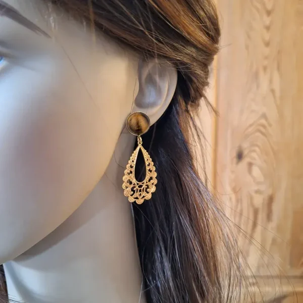 Schöne Ohrringe aus runden Ohrsteckern mit goldbraunem Tigerauge und langen, offenen Tropfen in Ornament Optik.