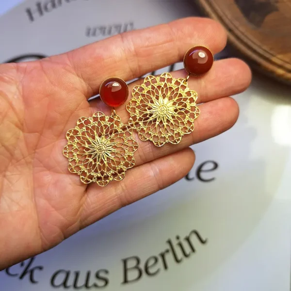 Liebevoll handgefertigte Ohrringe aus runden Ohrsteckern mit rotem Kareneol und federleichten runden Ornamenten, die orientalisch wirken.