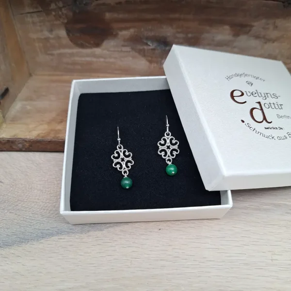 Schöne versilberte Ohrringe mit kleinen Ornamenten an denen unten eine grüne Jadeperle hängt