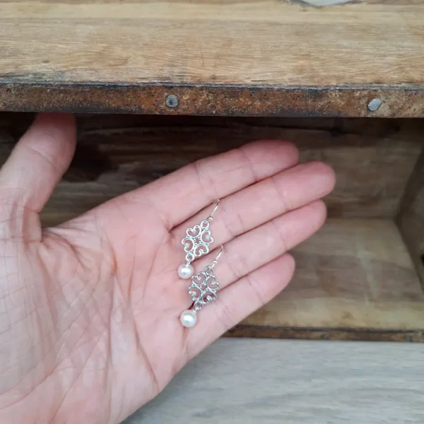Hängeohrringe mit Süßwasserperle und kleinem Ornament in Rautenform. Silber und versilbert